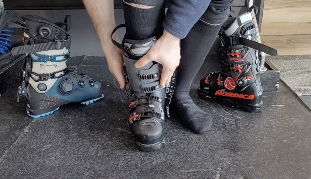 A skier buckles his ski boots.